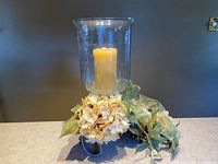 Hurricane candle holder assembled with floral arrangement and candle