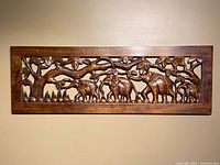 front view of carved wooden wall panel with elephants and tree