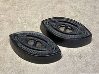 Both sad-iron bases top view showing maker stamps and condition