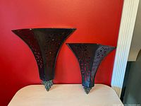 Front view of both metal wall pocket shelves against red wall