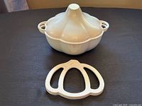 Garlic bulb Dutch oven with lid on trivet, front view