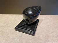 Front angled view of ebony snail hat pin holder on base
