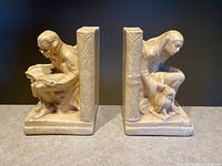 Both plaster bookends showing scholar and jester with central book spines