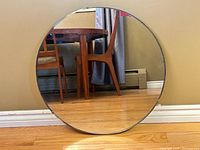 Front view of round beveled mirror leaning on wall