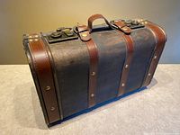 Angled view of entire trunk showing dome top, straps, handle and hardware