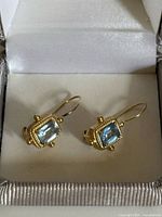 Pair of 14K gold drop earrings with pale blue stones in box – front view