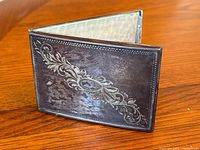 Front view showing engraved foliate design and patina