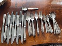 Full view of knives, forks and spoons laid out on table