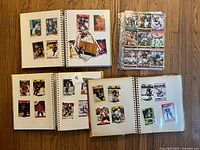 Overview: four albums and loose pages with trading cards on wood surface