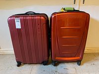 Front view of both red Samsonite hard-shell spinner suitcases