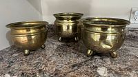 All three brass footed planters on countertop