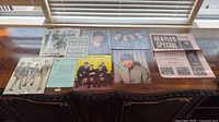 Overall view of assorted Beatles ephemera laid out on wooden surface