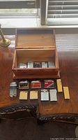 Overall lot showing cigar box and lighters arranged on table