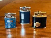 All three Ronson lighters side by side on table