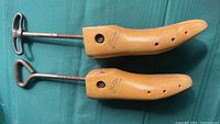 Top view of two Belcher wooden shoe stretchers showing wood grain, ventilation holes and metal screw handles