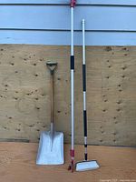 Full view of shovel, pruner and wash brush standing upright