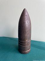 Front view of metal artillery shell-shaped paperweight
