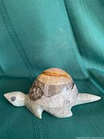 Side view of carved stone turtle showing shell colors and body shape