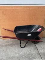 Side view showing full wheelbarrow profile, frame, wheel and handles