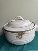 Front view of casserole dish with lid on, showing side handles and brushstroke accent