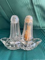 Salt and pepper shakers seated in matching tray, front view