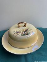 Covered dish assembled showing lid, handle, bird motif and plate