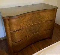 Front view of dresser showing serpentine profile and three drawers