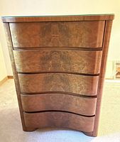 Front view showing serpentine drawers and veneer