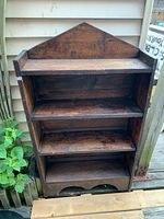 Front view showing four tiers, peaked back and arched base