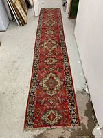 Full length view of red floral runner rug on floor