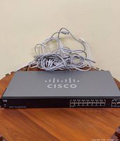 Front view of Cisco SG200-18 switch with bundled Ethernet cables