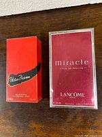 Front view of both sealed perfume boxes: Lancôme Miracle 100 ml and Paloma Picasso 30 ml.