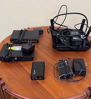 All hardware including router, two switches, PoE injectors, adapters and cables on tabletop