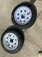 two trailer tires on white rims overview