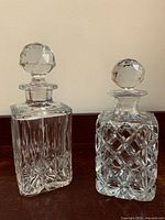 Both crystal decanters side by side showing overall shape and cut patterns