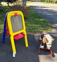 Rocking horse and easel side by side outdoors