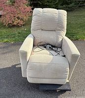 Front view of beige electric recliner with cords on seat