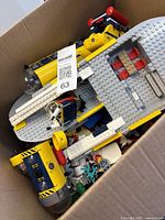 Top view of box showing yellow and grey submarine sections, loose LEGO pieces, minifigure and clear domes