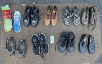 All items laid out on mat, showing eight pairs shoes, insoles packages and ice cleats