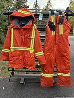 Full view of jacket and bib overall hanging, showing color, reflective tape, insulation