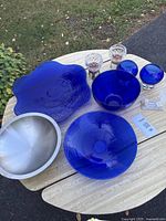 Overview of all blue glass bowls, platter, stainless bowl, candle holders