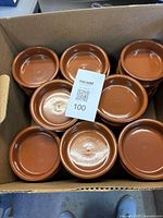 Box containing stacked terracotta dishes