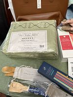 Overall lot showing sheet set, tote, cutlery, straw set