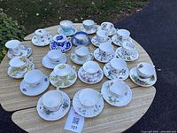 All 24 tea cup and saucer sets displayed on table