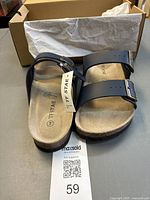 Top view of TF Star sandals with box and tag