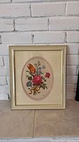 Oval floral artwork in gold frame