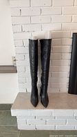 Front view of black over-the-knee boots standing side by side