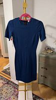Front view navy fitted sheath dress on hanger