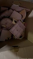 Disassembled pink and light purple castle wall panels inside box