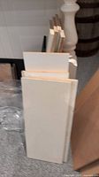 Front view of stacked white shelves with raw edges